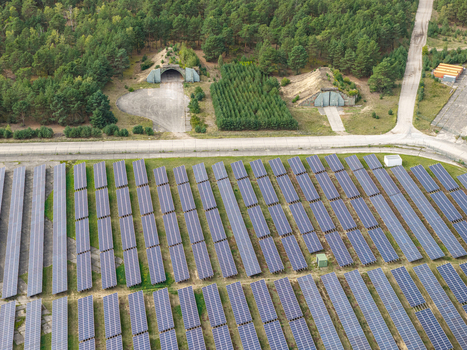 Aerial view of the solar field at the former military airfield in Preschen with historic hangars concrete taxiways and rows of solar panels in Neisse Malxetal Brandenburg Germany. Aerial view of the solar field at the former military airfield in Preschen with historic hangars concrete taxiways and rows of solar panels in Neisse Malxetal Brandenburg Germany.