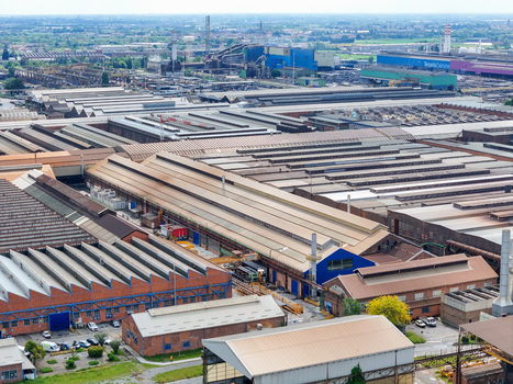 Aerial view of the Dalmine industrial complex featuring large factory warehouses and chimneys in Dalmine Lombardy Italy. Aerial view of the Dalmine industrial complex featuring large factory warehouses and chimneys in Dalmine Lombardy Italy.