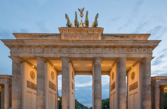 View of the Brandenburg Gate with its neoclassical columns and the Quadriga statue at dusk in Berlin Berlin Germany.