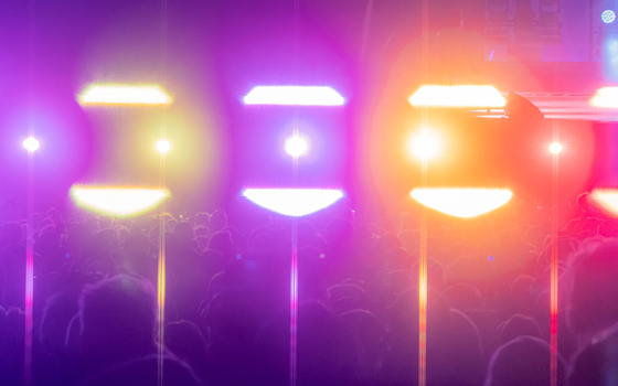 View of a large crowd at a music concert illuminated by bright colorful stage lights in Nyon Vaud Switzerland.