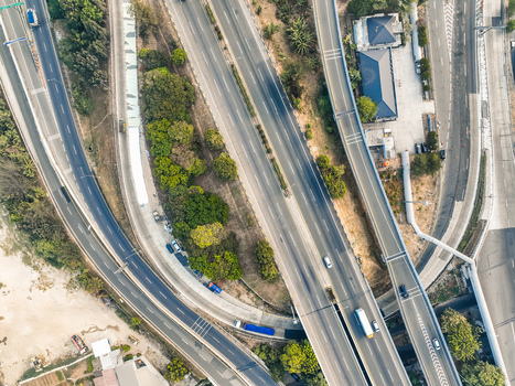 Aerial view of the Cikunir highway interchange with multi lane roads vehicles and surrounding greenery in Kecamatan Bekasi Selatan Jawa Barat Indonesia. Aerial view of the Cikunir highway interchange with multi lane roads vehicles and surrounding greenery in Kecamatan Bekasi Selatan Jawa Barat Indonesia.