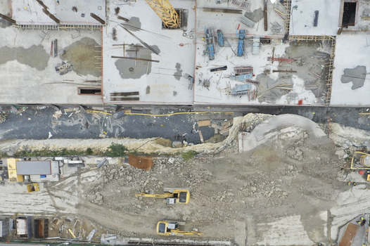 Aerial view of a large construction site featuring concrete foundations yellow excavators and heavy machinery on a dirt ground Avcilar Istanbul Turkiye. Aerial view of a large construction site featuring concrete foundations yellow excavators and heavy machinery on a dirt ground Avcilar Istanbul Turkiye.