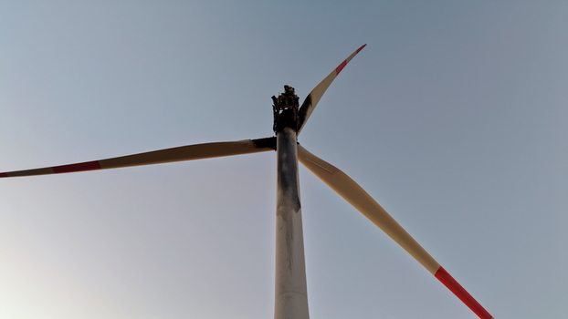 Aerial view of a damaged wind turbine with a scorched nacelle and blades against a clear sky in Vladimirovac Vojvodina Serbia.