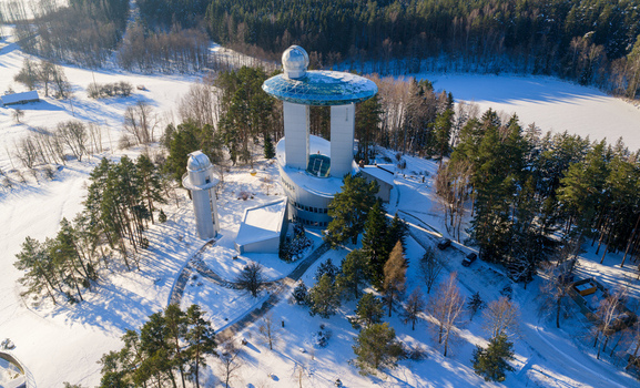 Aerial view of the Lithuanian Museum of Ethnocosmology with its futuristic architecture and glass deck surrounded by snow covered trees in Kulionys Utenos apskritis Lithuania.