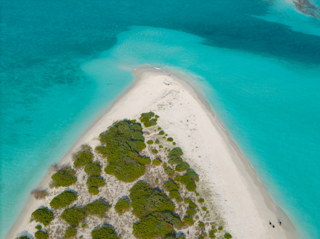 Aerial view of the white sand beach meeting the turquoise ocean Kan island Dhidhdhoo Thiladhunmathi Atoll Maldives.