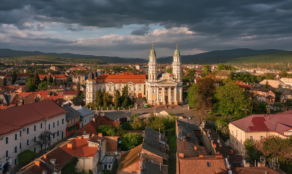 Aerial view of a grand cathedral with twin spires its white facade gleaming amidst the rustic rooftops under a dramatic sky Uzhhorod Zakarpattia Oblast Ukraine. Aerial view of a grand cathedral with twin spires its white facade gleaming amidst the rustic rooftops under a dramatic sky Uzhhorod Zakarpattia Oblast Ukraine.