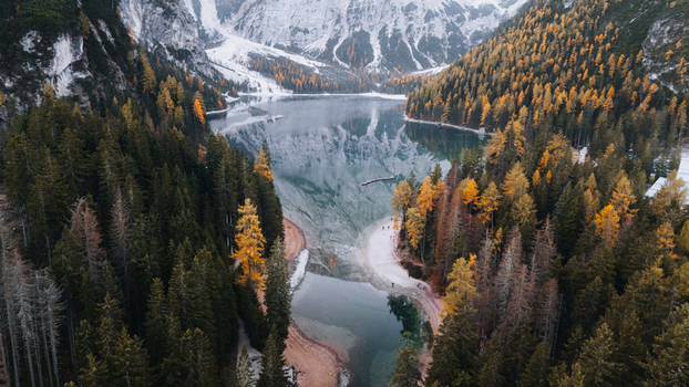 Aerial view of Lake Braies surrounded by autumn pine forests and snow capped mountains in Braies Trentino Alto Adige Italy. Aerial view of Lake Braies surrounded by autumn pine forests and snow capped mountains in Braies Trentino Alto Adige Italy.