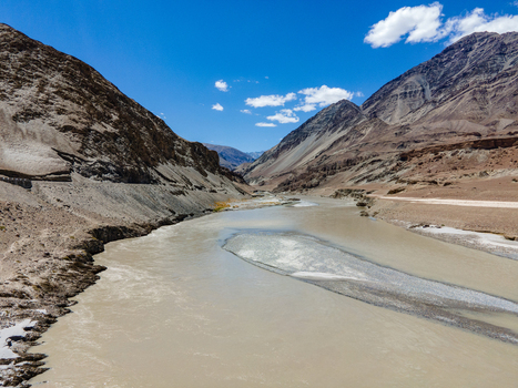 Aerial view of the Indus River flowing through the rugged arid mountain landscape of the Ladakh valley under a clear blue sky Ladakh Division Ladakh India. Aerial view of the Indus River flowing through the rugged arid mountain landscape of the Ladakh valley under a clear blue sky Ladakh Division Ladakh India.