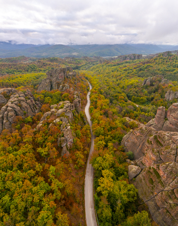 Aerial view of the Belogradchik Rocks surrounded by autumn forest and a winding road in Belogradchik Vidin Bulgaria. Aerial view of the Belogradchik Rocks surrounded by autumn forest and a winding road in Belogradchik Vidin Bulgaria.