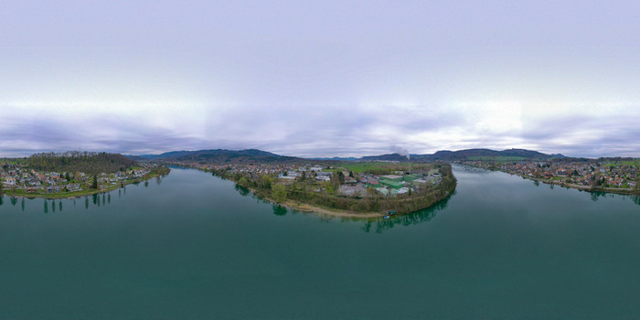 Aerial view of the Rhine River flowing through the town with industrial areas and forested hills under a cloudy sky in Bad Sackingen Baden Wurttemberg Germany. Aerial view of the Rhine River flowing through the town with industrial areas and forested hills under a cloudy sky in Bad Sackingen Baden Wurttemberg Germany.