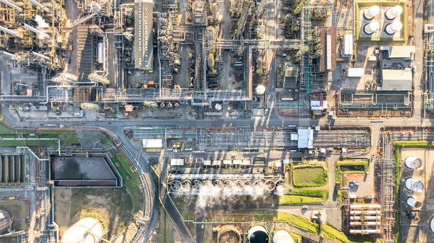 Aerial view of a large petrochemical complex with intricate piping networks industrial storage tanks cooling towers emitting steam and processing units in Santo Andre State of Sao Paulo Brazil.
