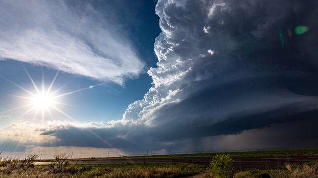 View of a dramatic supercell storm cloud with a bright sunburst over the flat landscape of Oklahoma City Oklahoma United States.