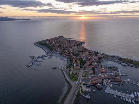 Aerial view of the historic town of Nessebar on the Black Sea coast at sunset featuring stone houses a harbor with boats and ancient fortifications in Nessebar Burgas Bulgaria. Aerial view of the historic town of Nessebar on the Black Sea coast at sunset featuring stone houses a harbor with boats and ancient fortifications in Nessebar Burgas Bulgaria.