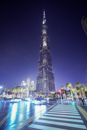 Dubai United Arab Emirates 19 April 2023 View of the Burj Khalifa illuminated at night with light trails from traffic on the street and palm trees. Dubai United Arab Emirates 19 April 2023 View of the Burj Khalifa illuminated at night with light trails from traffic on the street and palm trees.