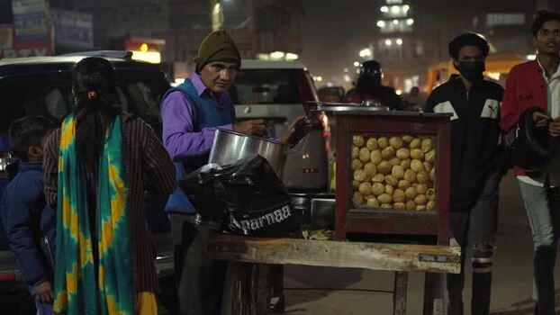 View of a street food vendor selling pani puri at night India.