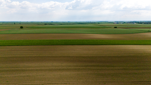 Aerial view of vast agricultural fields and cultivated land under a cloudy sky near Novi Sad Vojvodina Serbia. Aerial view of vast agricultural fields and cultivated land under a cloudy sky near Novi Sad Vojvodina Serbia.