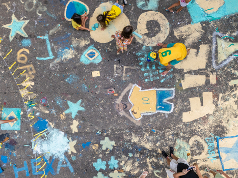 Rio de Janeiro Brazil 13 June 2026 Aerial view of people painting colorful street art with football themes stars and the word HEXA on asphalt during the World Cup 2026.