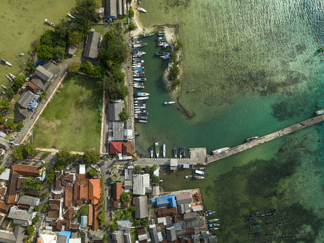 Aerial view of boats docked at the pier contrasting with the clear turquoise waters and the town s red tiled roofs Karimunjawa Central Java Indonesia. Aerial view of boats docked at the pier contrasting with the clear turquoise waters and the town s red tiled roofs Karimunjawa Central Java Indonesia.
