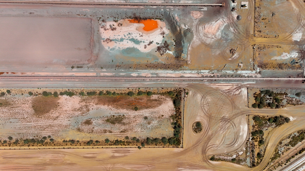 Aerial view of parched earth and vibrant orange pools showcasing a landscape shaped by both nature and industry Africa. Aerial view of parched earth and vibrant orange pools showcasing a landscape shaped by both nature and industry Africa.