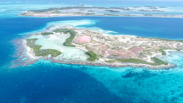 Aerial view of Los Roques archipelago with its pink salt flat mangroves and turquoise waters surrounding the sandy island. Los Roques Dependencias Federale Venezuela. Aerial view of Los Roques archipelago with its pink salt flat mangroves and turquoise waters surrounding the sandy island. Los Roques Dependencias Federale Venezuela.