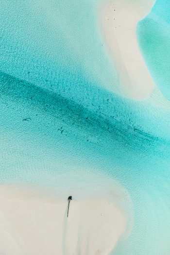 Aerial view of the turquoise Aitutaki lagoon with white sandbars and clear shallow water in the Cook Islands. Aerial view of the turquoise Aitutaki lagoon with white sandbars and clear shallow water in the Cook Islands.