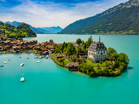Aerial view of the majestic Schloss Iseltwald rises from a verdant peninsula embraced by the turquoise waters of Lake Brienz Iseltwald Canton of Bern Switzerland. Aerial view of the majestic Schloss Iseltwald rises from a verdant peninsula embraced by the turquoise waters of Lake Brienz Iseltwald Canton of Bern Switzerland.