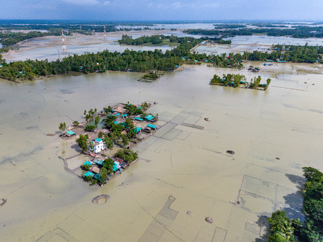 Aerial view of flooded landscape with submerged houses and trees surrounded by muddy water in Banshkhali Upazila Chittagong Division Bangladesh. Aerial view of flooded landscape with submerged houses and trees surrounded by muddy water in Banshkhali Upazila Chittagong Division Bangladesh.