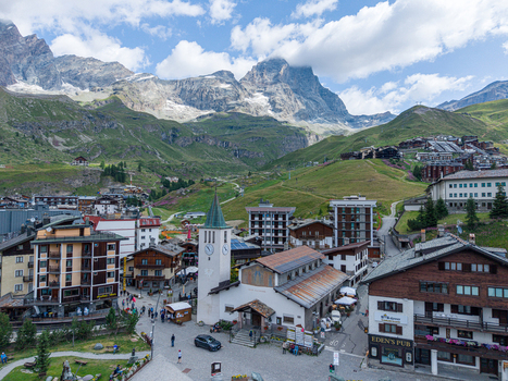 Aerial view of the mountain village of Breuil Cervinia with its church alpine architecture and the Matterhorn in the background Breuil Cervinia Aosta Valley Italy. Aerial view of the mountain village of Breuil Cervinia with its church alpine architecture and the Matterhorn in the background Breuil Cervinia Aosta Valley Italy.