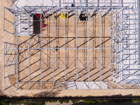 Aerial view of steel frame construction site with metal beams and long shadows cast on the dirt ground in Riga Latvia. Aerial view of steel frame construction site with metal beams and long shadows cast on the dirt ground in Riga Latvia.