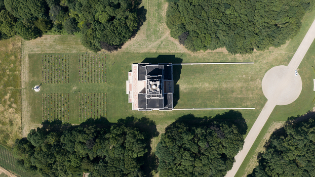 Aerial view of the Thiepval Memorial to the Missing of the Somme surrounded by lush green trees manicured lawns and rows of gravestones in Thiepval Hauts de France France.