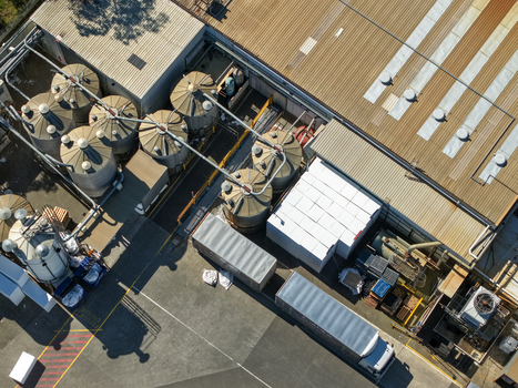 Kilsyth Australia 20 September 2026 Aerial view of an industrial facility with metal storage silos a warehouse building and trucks parked in the loading yard. Kilsyth Australia 20 September 2026 Aerial view of an industrial facility with metal storage silos a warehouse building and trucks parked in the loading yard.