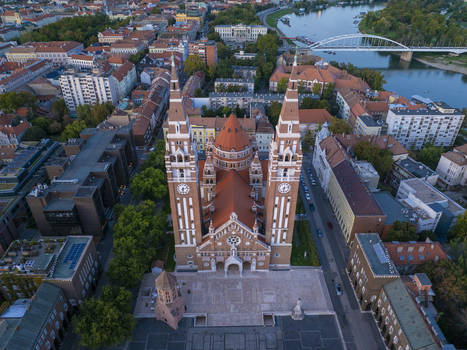 Aerial view of Szeged Cathedral with its twin towers and red tiled roof overlooking the historic city square and the Tisza River in Szeged Hungary. Aerial view of Szeged Cathedral with its twin towers and red tiled roof overlooking the historic city square and the Tisza River in Szeged Hungary.