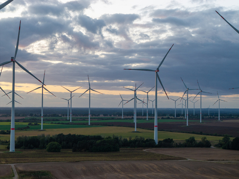 Aerial view of Sieversdorf Windpark with numerous wind turbines standing in agricultural fields under a dramatic cloudy sky at sunset Jacobsdorf Brandenburg Germany. Aerial view of Sieversdorf Windpark with numerous wind turbines standing in agricultural fields under a dramatic cloudy sky at sunset Jacobsdorf Brandenburg Germany.