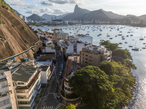 Aerial view of Urca neighborhood with its characteristic steep hillside urban buildings and boats anchored in Guanabara Bay in Rio de Janeiro Rio de Janeiro Brazil.