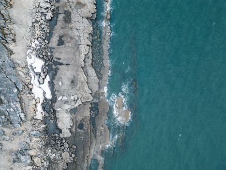 Svalbard and Jan Mayen 28 July 2025 Aerial view of the rugged rocky coastline with jagged grey cliffs and patches of snow meeting the deep turquoise waters of the Arctic Ocean. Svalbard and Jan Mayen 28 July 2025 Aerial view of the rugged rocky coastline with jagged grey cliffs and patches of snow meeting the deep turquoise waters of the Arctic Ocean.