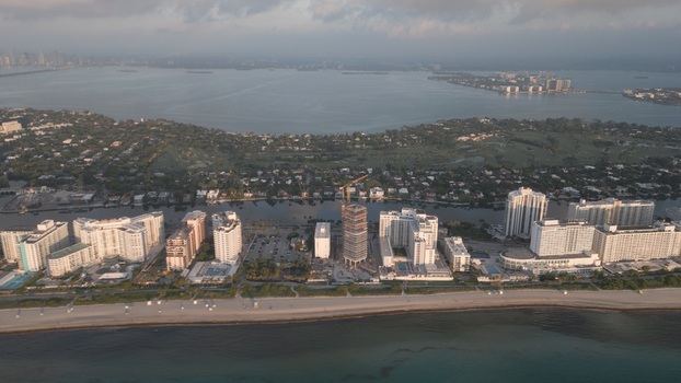 Aerial view of the Miami Beach coastline featuring high rise hotels residential buildings a construction site with a crane and the Atlantic Ocean in Miami Beach Florida United States. Aerial view of the Miami Beach coastline featuring high rise hotels residential buildings a construction site with a crane and the Atlantic Ocean in Miami Beach Florida United States.