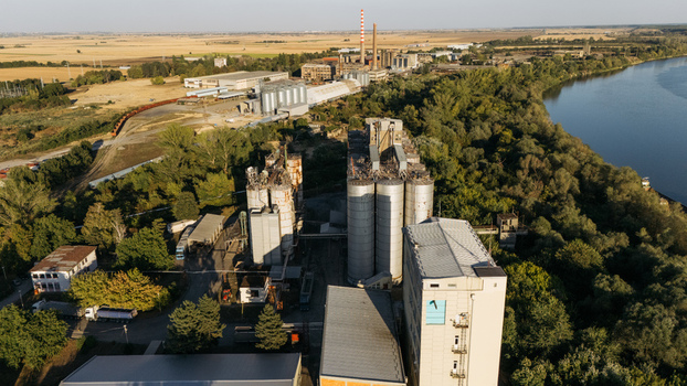 Aerial view of an industrial facility with large grain silos and factory buildings situated along the riverbank in Sremska Mitrovica Vojvodina Serbia. Aerial view of an industrial facility with large grain silos and factory buildings situated along the riverbank in Sremska Mitrovica Vojvodina Serbia.