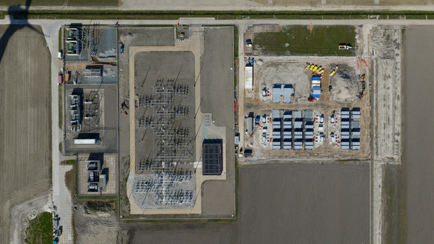 Aerial view of Hoogspanningsstation Westermeerdijk featuring the electrical substation with transformers switchyard and battery storage containers in Espel Flevoland Netherlands.
