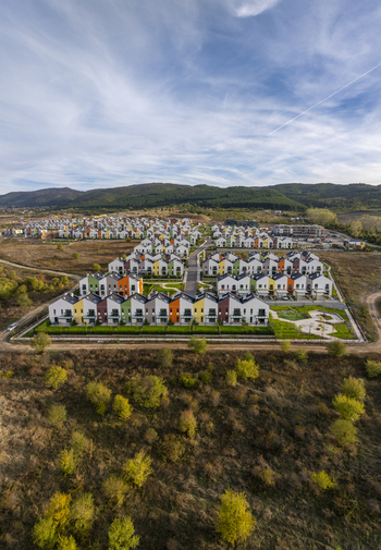 Aerial view of Residential Park Lozen featuring rows of modern colorful townhouses with pitched roofs and green lawns under a blue sky in Sofia Sofia City Province Bulgaria. Aerial view of Residential Park Lozen featuring rows of modern colorful townhouses with pitched roofs and green lawns under a blue sky in Sofia Sofia City Province Bulgaria.