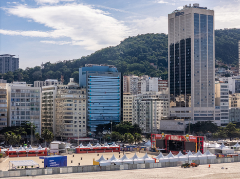 Rio de Janeiro Brazil 13 June 2026 Aerial view of the FIFA World Cup 2026 fan zone on Copacabana beach with white tents and a large stage set against the city skyline and hills.
