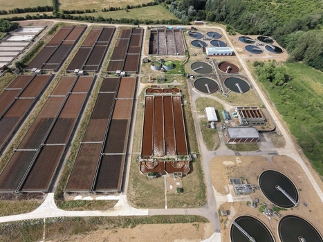 Aerial view of Broadholme water recycling centre showing large rectangular treatment tanks circular sedimentation basins and surrounding green landscape in Rushden England United Kingdom. Aerial view of Broadholme water recycling centre showing large rectangular treatment tanks circular sedimentation basins and surrounding green landscape in Rushden England United Kingdom.