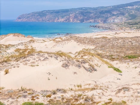 Aerial view of Praia do Guincho with expansive sand dunes turquoise ocean waters and rugged coastal cliffs Cascais Lisbon Portugal. Aerial view of Praia do Guincho with expansive sand dunes turquoise ocean waters and rugged coastal cliffs Cascais Lisbon Portugal.