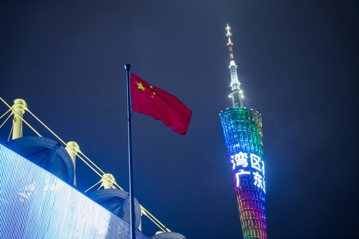 Guangzhou China 24 February 2024 View of the illuminated Canton Tower at night with the Chinese national flag waving in the foreground. Guangzhou China 24 February 2024 View of the illuminated Canton Tower at night with the Chinese national flag waving in the foreground.