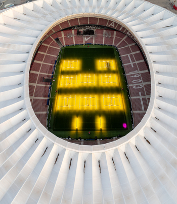 Aerial view of Riyadh Air Metropolitano Stadium in Madrid featuring its distinctive white roof structure and illuminated pitch Madrid Comunidad de Madrid Spain.
