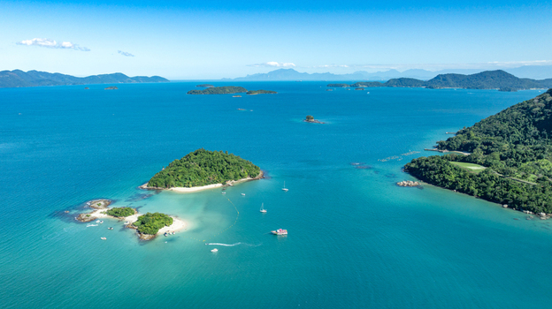 Aerial view of Ilha de Cataguas with turquoise waters small boats and lush vegetation in Angra dos Reis Rio de Janeiro Brazil.