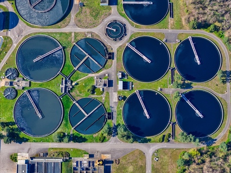 Aerial view of circular water treatment tanks contrasting with the surrounding green landscape Sausheim Grand Est France.