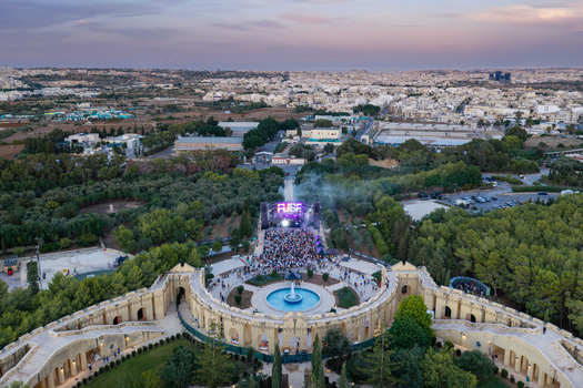 Attard Northern Region Malta 20 September 2026 Aerial view of the Fuse music festival at Park Nazzjonali Ta Qali with a central fountain crowded stage and surrounding trees. Attard Northern Region Malta 20 September 2026 Aerial view of the Fuse music festival at Park Nazzjonali Ta Qali with a central fountain crowded stage and surrounding trees.