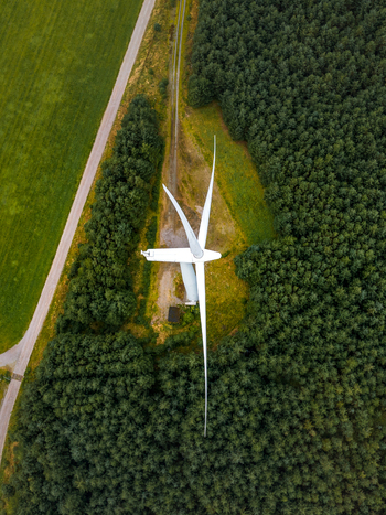 Aerial view of a wind turbine at Hog Jaeren wind farm surrounded by dense forest and green fields in Ha Municipality Rogaland Norway. Aerial view of a wind turbine at Hog Jaeren wind farm surrounded by dense forest and green fields in Ha Municipality Rogaland Norway.