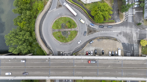 Aerial view of Ponte do Ribeirino bridge and a busy roundabout with vehicles and lush green trees in Ourense Ourense Spain.