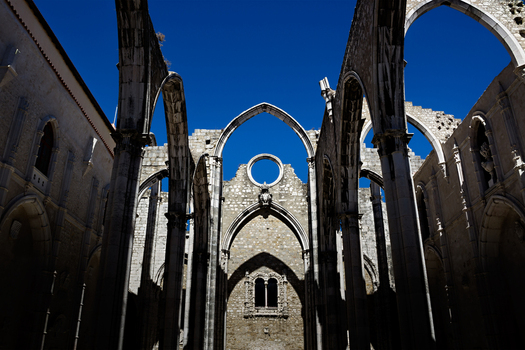 View of the Gothic arches and stone ruins of the Carmo Convent under a clear blue sky in Lisbon Lisbon Portugal. View of the Gothic arches and stone ruins of the Carmo Convent under a clear blue sky in Lisbon Lisbon Portugal.
